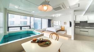 Habitación de hotel con piscina y dormitorio en Busan Graysands, en Busan