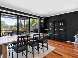 een eetkamer met zwarte muren en een tafel en stoelen bij Beautiful and peaceful house 500m to Knights beach in Port Elliot