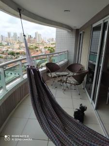 a dog sitting in a hammock on a balcony at Vista espetacular da Praia de Iracema - Ap. 1405 in Fortaleza