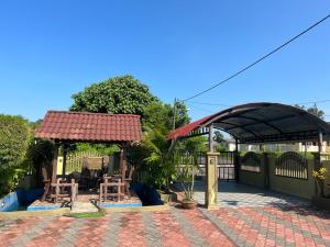 een paviljoen met tafels en stoelen op een patio bij Homestay Nukman Bukit Besi in Dungun