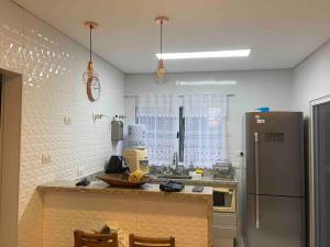 een keuken met een aanrecht en een koelkast bij Sobrado moderno, piscina privativa, condomínio Morada da Praia! in Bertioga