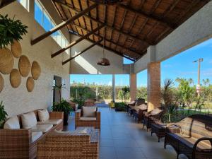 an outdoor patio with couches and tables and windows at Muro Alto Condomínio Clube Porto de Galinhas por Brevelar in Porto De Galinhas