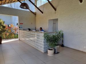 a woman sitting at a counter in a building at Muro Alto Condomínio Clube Porto de Galinhas por Brevelar in Porto De Galinhas