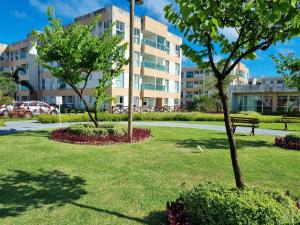 two trees in a park with a building in the background at Muro Alto Condomínio Clube Porto de Galinhas por Brevelar in Porto De Galinhas +57 photos