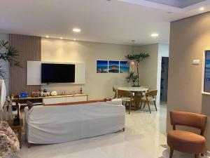 een woonkamer met een witte bank en een tafel bij Sobrado moderno, piscina privativa, condomínio Morada da Praia! in Bertioga