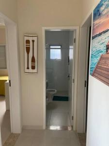 een witte badkamer met een toilet en een wastafel bij Sobrado moderno, piscina privativa, condomínio Morada da Praia! in Bertioga