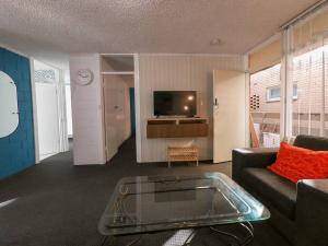 a living room with a couch and a tv at Glenelg Air B & B in Glenelg