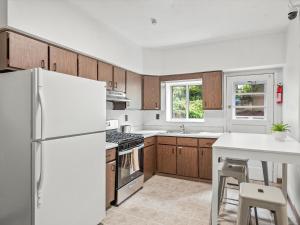 a kitchen with wooden cabinets and a white refrigerator at Oakland/University @B Quiet & Stylish Private Bedroom with Shared Bathroom in Pittsburgh