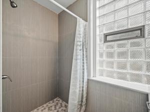 a shower with a shower curtain and a window at Oakland/University @B Quiet & Stylish Private Bedroom with Shared Bathroom in Pittsburgh