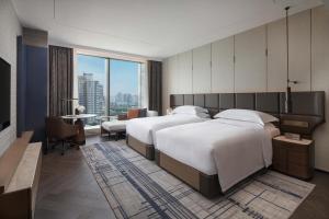 2 letti in camera d'albergo con vista di InterContinental Hotels Zhengzhou a Zhengzhou