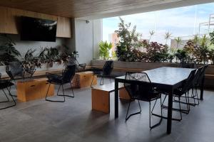 Cette chambre comprend une table, des chaises et des plantes. dans l'établissement Apartamento Granat cerca del aeropuerto y la zona cultural y gastronómica, à Guatemala