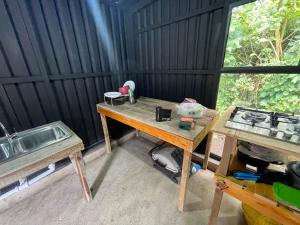 een kamer met een tafel, een fornuis en een wastafel bij Ricks hostel in Juayúa