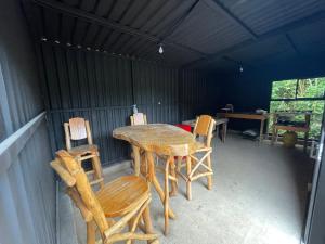 Habitación con porche con mesa y sillas. en Ricks hostel, en Juayúa