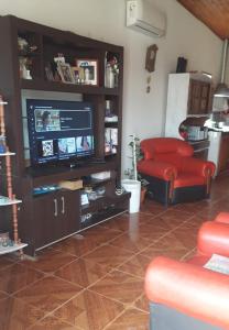 sala de estar con TV y silla roja en La Nona, en El Carmen 6 fotos más