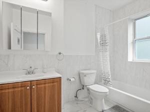 Baño blanco con aseo y lavamanos en Oakland/University @C Modern & Stylish Private Bedroom with Shared Bathroom en Pittsburgh