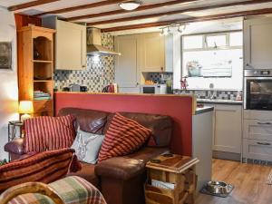 a living room with a couch and a kitchen at Ty Tarth in Pen-y-groes