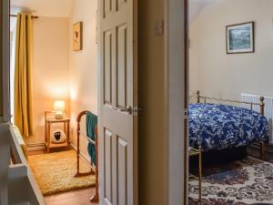 a small bedroom with a bed and a door at Ty Tarth in Pen-y-groes