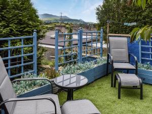 a patio with chairs and a table and a view of the water at Ty Tarth in Pen-y-groes