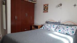 Schlafzimmer mit einem Bett und einem Holzschrank in der Unterkunft La Nona in El Carmen