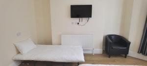 1 dormitorio con 1 cama y 1 silla negra en Entire 2 bedroom Apt in central location, Newly Refurbished, en Plymouth