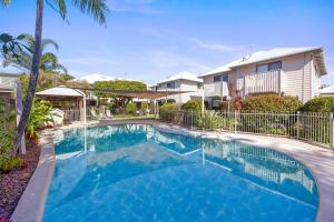 a swimming pool in front of a house at Terrapin Apartments in Noosaville