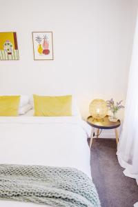 a bedroom with a white bed and a table at Cozy Home Close to Beach and Hobart CBD in Hobart