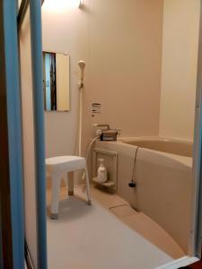 a bathroom with a stool and a bath tub at 民宿 和合 Minshuku WAGO in Tanabe
