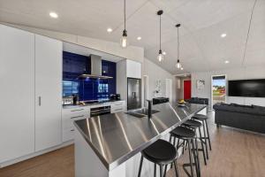 cocina y sala de estar con encimera y taburetes en The Red Door, en Martinborough
