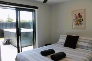 Un dormitorio con una cama y una puerta corrediza de vidrio. en The Red Door, en Martinborough 17 fotos más
