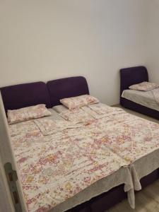 a bed with a quilt and pillows on it at Apartment Marijana in Tivat