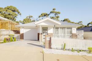 a house with a white fence in front of it at Cozy Home Close to Beach and Hobart CBD in Hobart