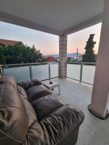 a leather couch sitting on top of a balcony at Apartment Marijana in Tivat