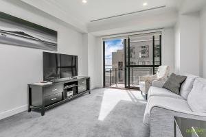 a living room with a couch and a large window at QV Private City Hub Apartment - 484 in Auckland