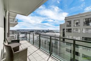 a balcony with chairs and a view of an airport at QV Private City Hub Apartment - 484 in Auckland