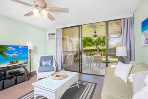 ワイレアにあるRemodeled 1BR 2BA at Kamaole Sands - Steps to Beach!のソファとテレビのあるリビングルーム