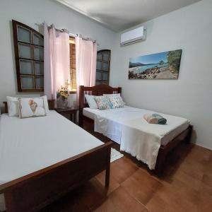 um quarto com 2 camas e uma janela em Espaço Villa Ará em Praia de Araçatiba