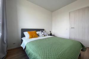 a bedroom with a bed with a green comforter at شقة مريحة مع تكييف الهواء والتجديد in ‘Izbat al Kūbānīyah