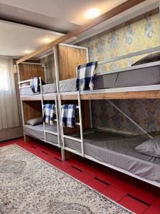 four bunk beds in a room with a red floor at InJoy in Shymkent