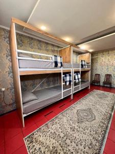 a room with bunk beds with a red tile floor at InJoy in Shymkent