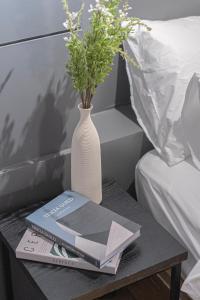 une table avec un vase, un livre et des fleurs dans l'établissement BY THS Valentine Hotel Incheon, à Siheung