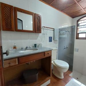 uma casa de banho com um lavatório, um WC e um chuveiro em Espaço Villa Ará em Praia de Araçatiba