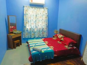 A bed or beds in a room at Teratak Desa Umaira