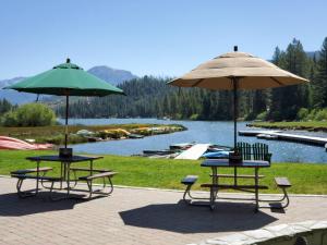two tables with umbrellas and chairs next to a lake at Sequoia Glen in Wilsonia