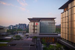 un bâtiment avec un panneau rouge à côté des bâtiments dans l'établissement Guangzhou Marriott Hotel Baiyun, à Canton