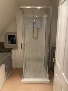 a shower with a glass shower stall in a bathroom at Honeycomb Cottage in Newburgh