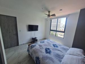 um quarto com uma cama e uma televisão de ecrã plano em Espectacular apartamento en calle 50 na Cidade do Panamá
