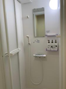 a bathroom with a shower and a mirror at 海に恋する泊まれる喫茶店 ポパイ in Iyo