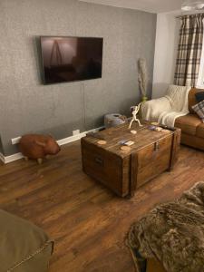 una sala de estar con una mesa de centro de madera y un cerdo en el suelo en Honeycomb Cottage, en Newburgh