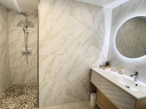 een badkamer met een douche, een wastafel en een spiegel bij Espace privé - Gîte & Spa 