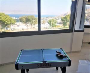 una mesa de ping pong con un par de tijeras. en 4bdrm - 110mr - Dream vacation apartment en Tiberias